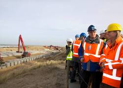 Minister Schultz van Haegen krijgt uitleg over de dijk in duin tijdens een werkbezoek op 6 februari 2014